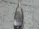 a silver spoon on a table with a spoon on it