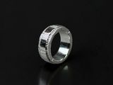a close up of a silver ring with diamonds on a black surface