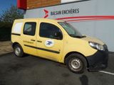une petite camionnette jaune garée devant un immeuble