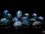 some very pretty blue and green oplite stones on a black surface