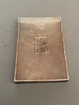 an antique silver cigarette case with a picture of a man on it