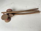 two wooden sticks and a ball on a white surface