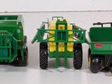 four green toy tractors sitting next to each other on a white surface