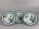a set of four blue and white plates with flowers on them
