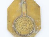 a small brass plate with a clock on top of it