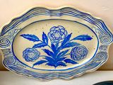 a blue and white plate with a flower on it