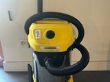 a yellow vacuum cleaner sitting on top of a black floor