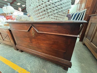 un grand coffre en bois orné d'un motif décoratif sur le dessus