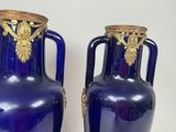 pair of blue vases with gold handles on a white surface