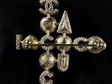 a close up of a metal cross with a snake on it