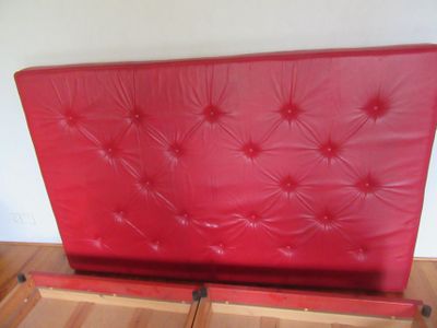 un lit rouge surmonté d'une tête de lit rouge