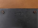 a close up of a metal plaque on a brown surface