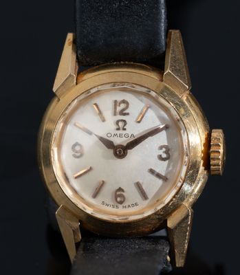 gros plan d'une montre en or sur une surface noire