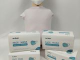 three boxes of face masks sitting next to a mannequin head