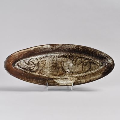 une image représentant une assiette marron et blanche sur laquelle figure une inscription