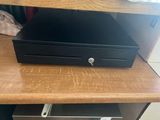 une petite boîte noire posée sur un bureau en bois