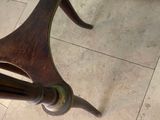 a wooden table with a glass top on a tile floor