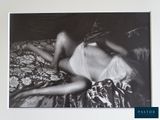 a black and white photo of a woman laying on a bed