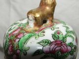 a small ceramic animal sitting on top of a flower covered box