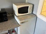 a microwave on top of a refrigerator in a kitchen
