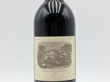 une vieille bouteille de vin rouge posée sur une table blanche