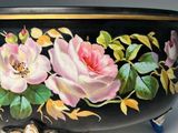 a black bowl with pink flowers painted on it