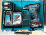 une boîte à outils bleue contenant une perceuse et deux batteries