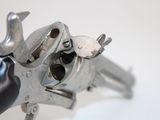a close up of a gun on a white surface