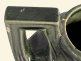 a green vase that has a handle on it