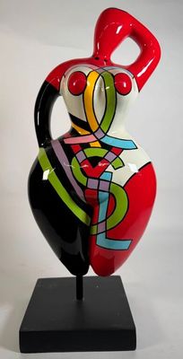 un vase coloré posé sur un socle noir, sur fond blanc
