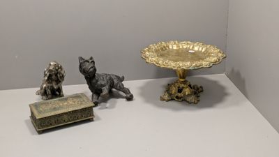 trois figurines posées sur une table, à côté d'un bol