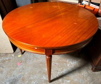 une table ronde avec un plateau en bois, posée à même le sol