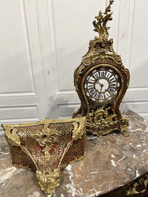 une horloge posée sur une table, à côté d'un bol