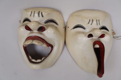 une paire de masques blancs à la bouche ouverte sur un fond blanc