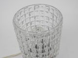 a glass candle holder with a wire attached to it