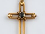 une image représentant une croix en or ornée d'une pierre noire