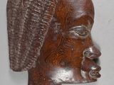 a wooden sculpture of a woman ' s head on the wall