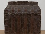an old wooden chest sitting on top of a table next to a white wall