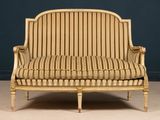 an antique french style sofa with striped upholstered upholstered cushions