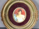 une photo d'une femme en robe bleue, dans un cadre doré