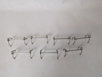 five pairs of hooks on a white surface