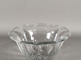 un saladier en verre transparent posé sur une surface blanche, avec un fond gris clair