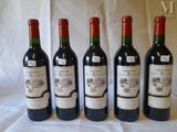 four bottles of wine are lined up on a table