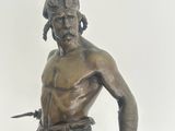 a bronze statue of a man holding a knife