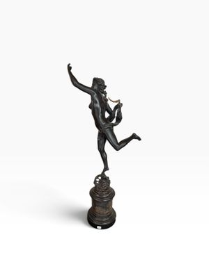 une statue en bronze d'une femme tenant un oiseau sur un piédestal