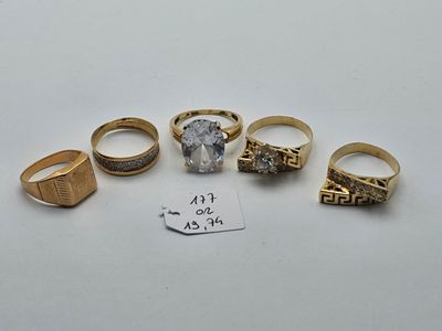 five different rings and a price tag on a white surface