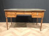 a wooden desk with marble top on a chevroned wood floor