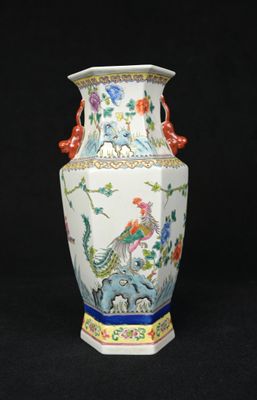 un vase orné d'un oiseau et de fleurs sur fond noir