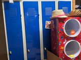une pile de cartons et de boîtes dans une pièce équipée de casiers bleus