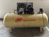 un petit compresseur d'air posé sur un support dans un garage